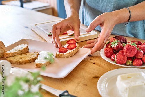 Photos Woman making summer strawberry sandwich