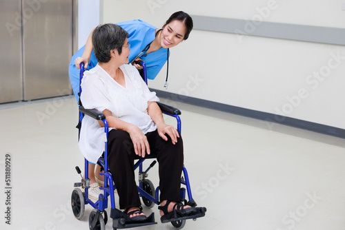Young asian doctor in blue uniform and senior woman holding hands together. Positive Asian woman caregiver helping patient.
