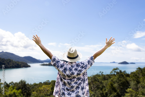 Man standing on beach back to camera looking at sea nature tour