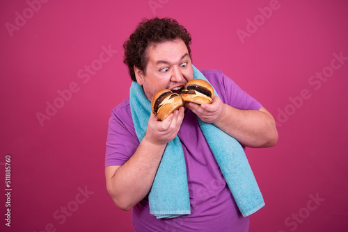 Diet and fast food. Funny fat man eats a hamburger.