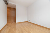 Empty room with built in oak wardrobe, gray air conditioner and light oak floor