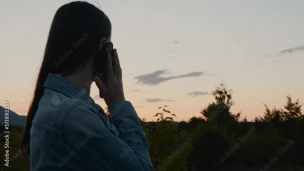 Silhouette of young woman stand outdoor use mobile phone call talk with friend. Attractive beautiful girl enjoy spend leisure time on weekend activity, communicate online in evening at summer park Silhouette of young woman stand outdoor use mobile phone call talk with friend. Attractive beautiful girl enjoy spend leisure time on weekend activity, communicate online in evening at summer park