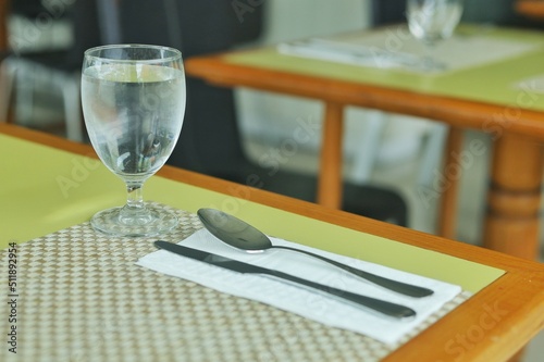 Obraz na płótnie The set of utensil such as glass fork and spoon set on the table for having meal at restaurant or hotel. w salonie