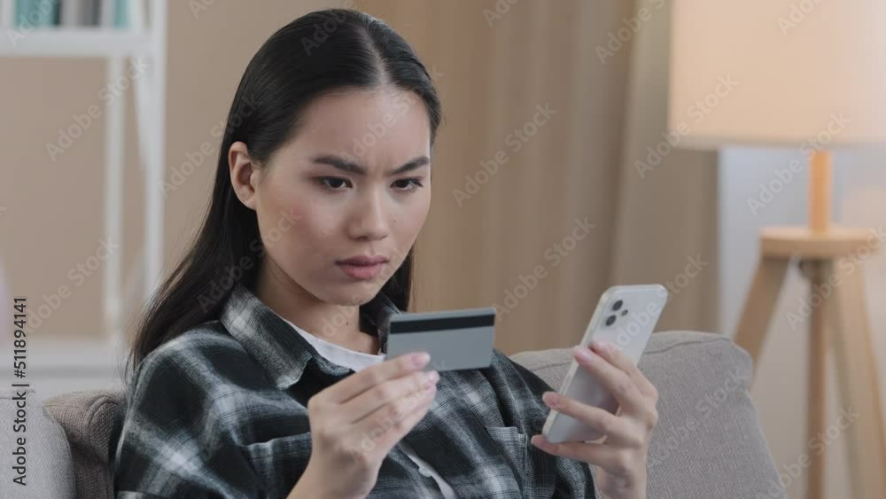 Angry puzzled Asian woman try to pay with e-bank app online service has problem with credit card blocked financial limit not activated for internet payment unsuccessful transaction with phone error Angry puzzled Asian woman try to pay with e-bank app online service has problem with credit card blocked financial limit not activated for internet payment unsuccessful transaction with phone error