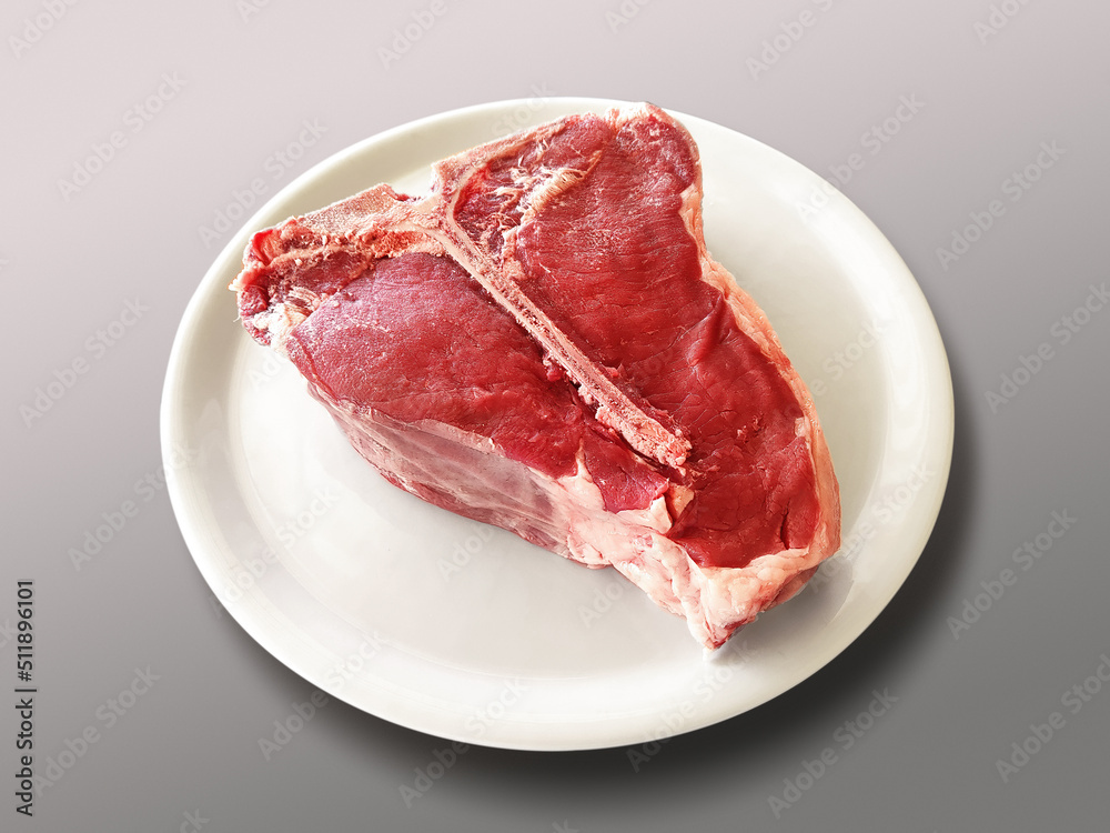 Round white plate with raw Fiorentina t-bone steak beef porterhouse Round white plate with raw Fiorentina t-bone steak beef porterhouse