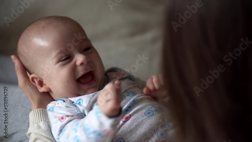 Newborn Baby With Young Mom look Into Each Other Eye. Cute Smiling Teethless Kid Face Portrait. Woman Kissing With Child Look At Camera. Infant, Mother Day, Childbirth, Beginning, Relationship Concept photo