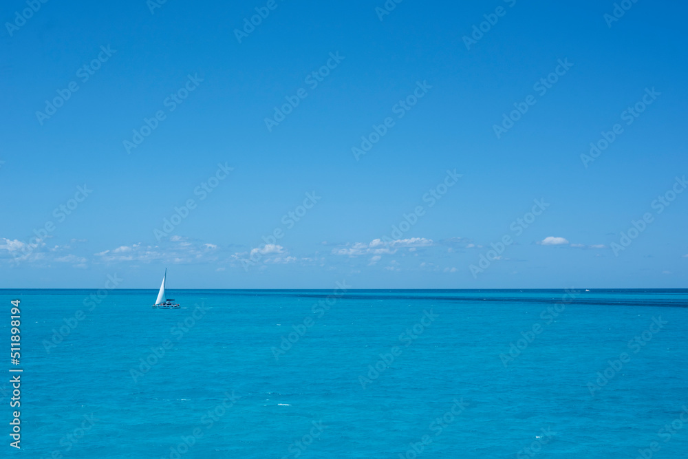 A sailboat on the sea in the tropics against the blue sky of a summer day. Travel vacations A sailboat on the sea in the tropics against the blue sky of a summer day. Travel vacations