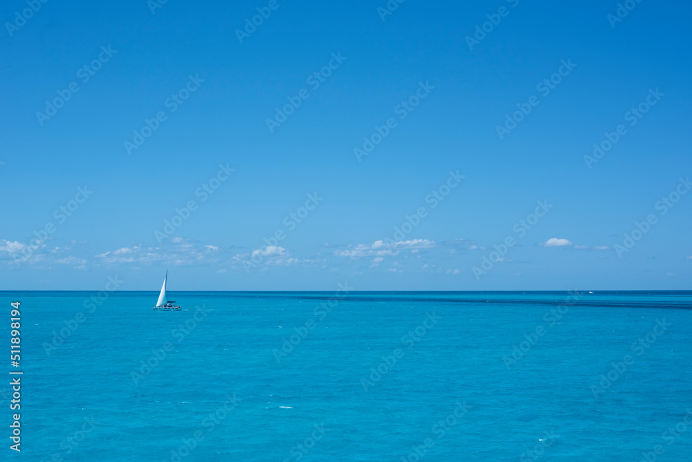 A sailboat on the sea in the tropics against the blue sky of a summer day. Travel vacations