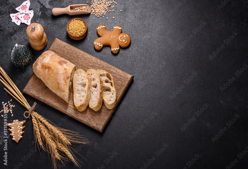 French baguette bread sliced on a wooden cutting board against a dark concrete background