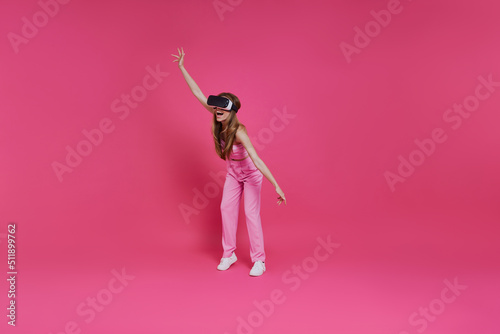 Full length of beautiful young woman in virtual reality headset having fun © gstockstudio