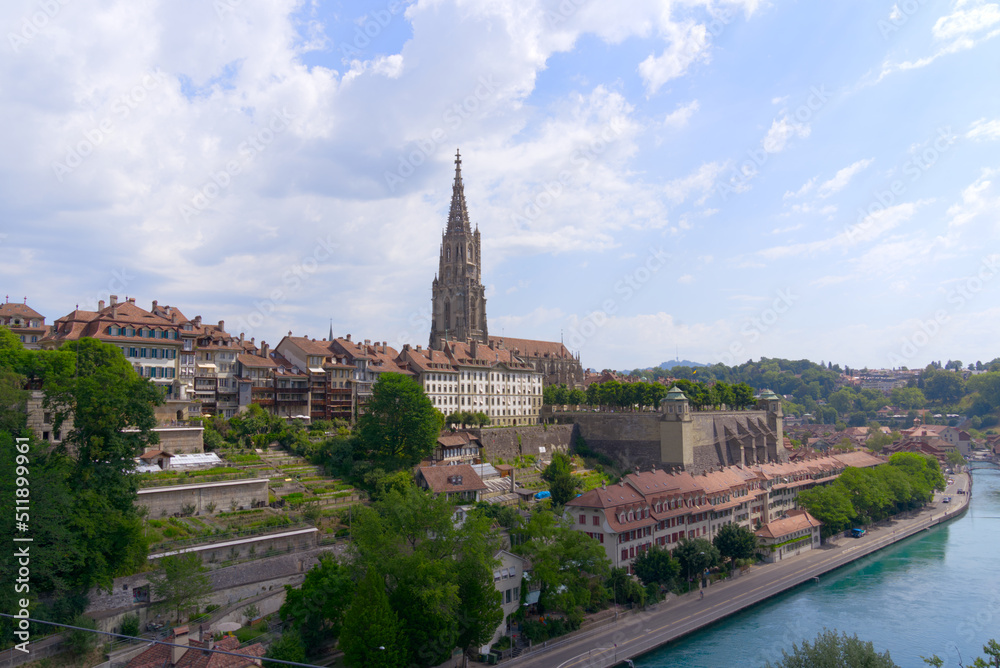 Aerial view of the old town of City of Bern with historic houses, Minster and Aare River on a blue cloudy summer day. Photo taken June 16th, 2022, Bern, Switzerland.
