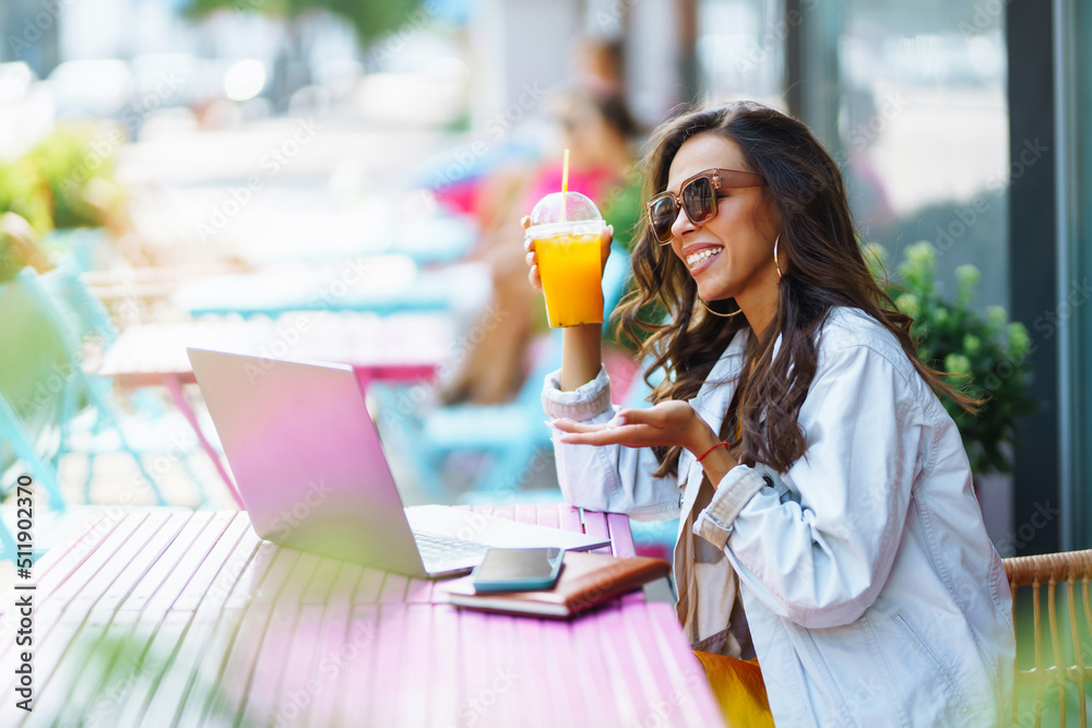 Portrait of happy young woman with a laptop at cafe. Freelancer working on a laptop. Business, online, education concept. Portrait of happy young woman with a laptop at cafe. Freelancer working on a laptop. Business, online, education concept.
