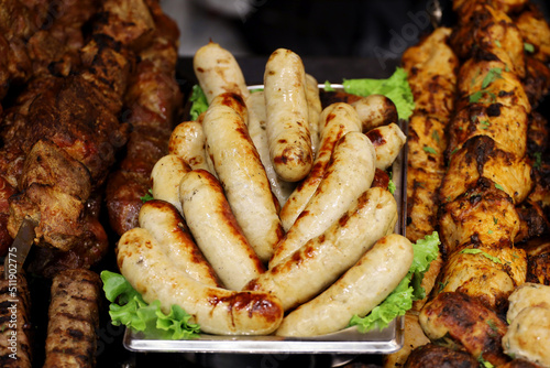 Sausages and kebab served with lettuce leaves, grilled meat
