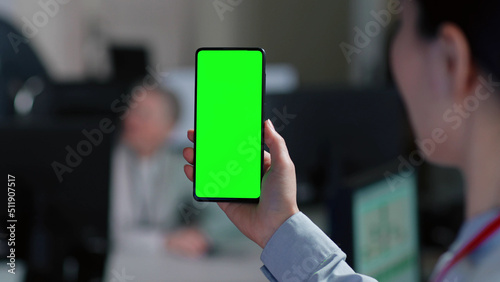 Close up of woman holding smartphone with green screen