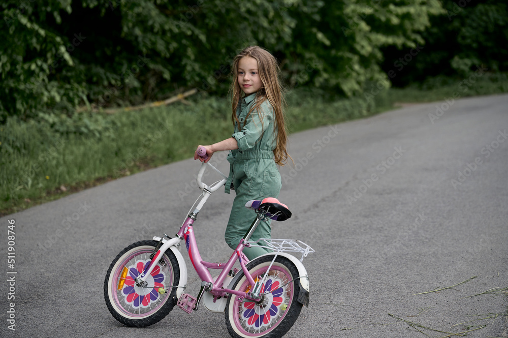 happy cheerful child girl riding a bike in Park in the nature.