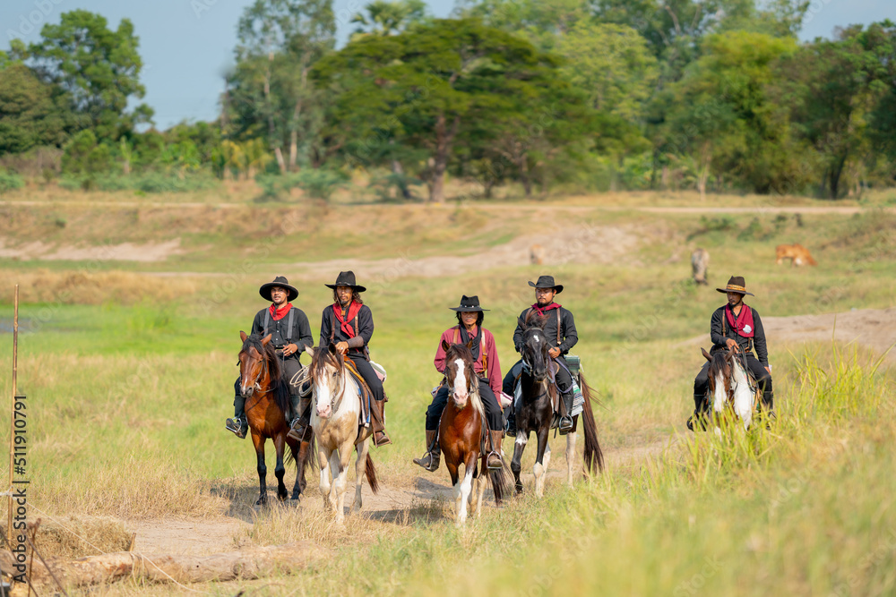 Group of cowboy on horse are riding to the village after finish take care of cow in background. Group of cowboy on horse are riding to the village after finish take care of cow in background.
