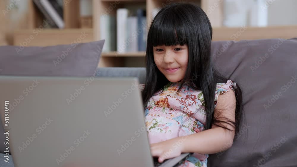 Curious cute preschool kid girl watching internet video course at home desk. back to School, Online learning, distance lesson, education at home, doing homework at home. Children tech addiction. Curious cute preschool kid girl watching internet video course at home desk. back to School, Online learning, distance lesson, education at home, doing homework at home. Children tech addiction.