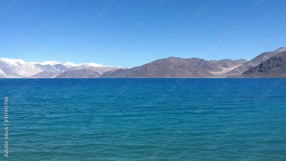 Aerial view by drone of beautiful Pangong Lake, the world’s highest saltwater lake which seems to be dyed in blue, surrounded by amazing snow mountains range with a clear blue sky in the background Aerial view by drone of beautiful Pangong Lake, the world’s highest saltwater lake which seems to be dyed in blue, surrounded by amazing snow mountains range with a clear blue sky in the background