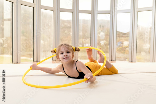 Little blonde girl with piggy tails playing with hula hoop
