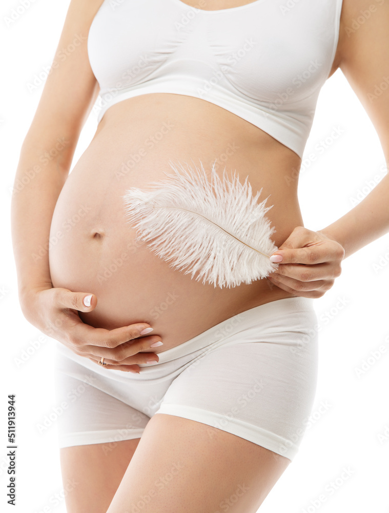 Pregnant Woman Belly Skin Care. Future Mother in White Cotton Underwear  embrace Abdomen and massage with Feather. Pregnancy Healthy Cosmetics.  Maternity Body Beauty Concept over isolated Background Photos
