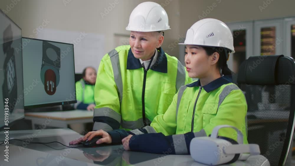 Portrait of project supervisor talking with a female industrial engineer point at computer screen Portrait of project supervisor talking with a female industrial engineer point at computer screen