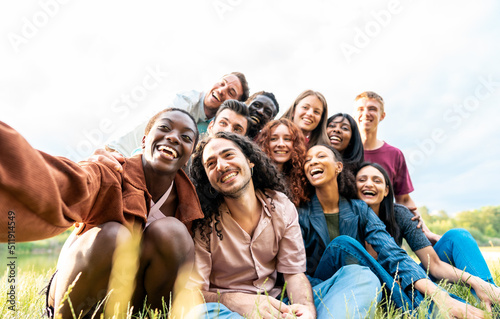 African young woman taking a selfies of his international friends during a picnic