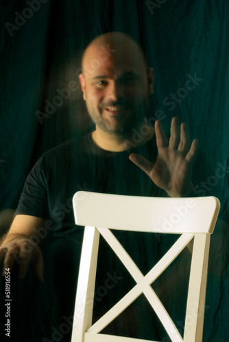 cheerful man in twilight with a chair