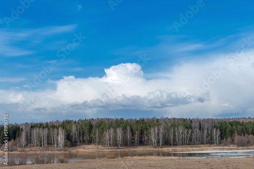 Spring landscape. Early spring. A lake with ice and beautiful thundery skies.