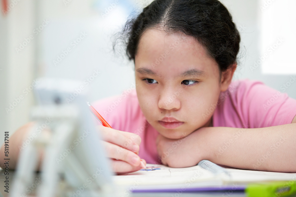 asia young girl learning online at home with wring book asia young girl learning online at home with wring book