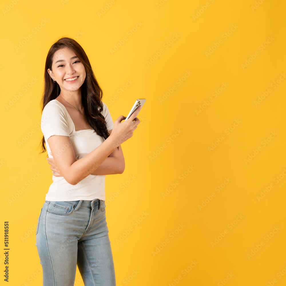 Smiling asian woman white shirt on yellow background use smartphone with happy feeling show appreciation Smiling asian woman white shirt on yellow background use smartphone with happy feeling show appreciation