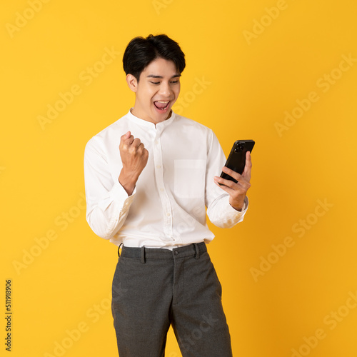 Good looking teenage asian man with laugh isolate on yellow background happy for win loterry photo