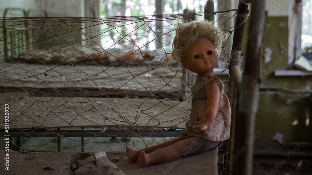 Close up plastic doll on rusty beds in abandoned kindergarten in city Pripyat near Chernobyl nuclear power plant. Exclusion radioactive zone, ghost town, Ukraine. Radiation, catastrophe