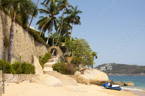 Playa de acapulco con mar, arena y palmeras en México