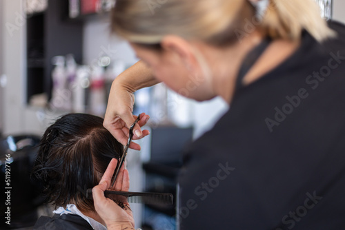 Cutting hair at hairdresser. Treat hair at beauty salon. Closeup. Selective focus
