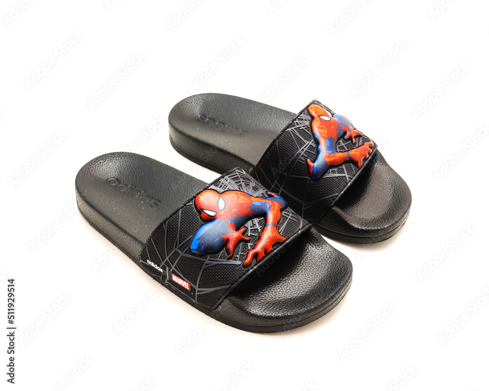 Obraz premium Pair of adilette shower slides sandal style with an open toe and print design of Spiderman from Adidas isolated on white background