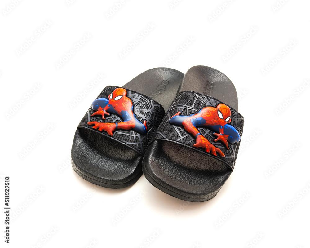 Fototapeta premium Pair of adilette shower slides sandal style with an open toe and print design of Spiderman from Adidas isolated on white background