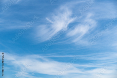 Blue sky with beautiful light white cirrus clouds on a warm sunny day.
