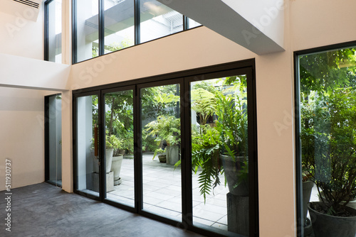 Slide glass window in modern empty room and overlooking the surrounding garden and forest.