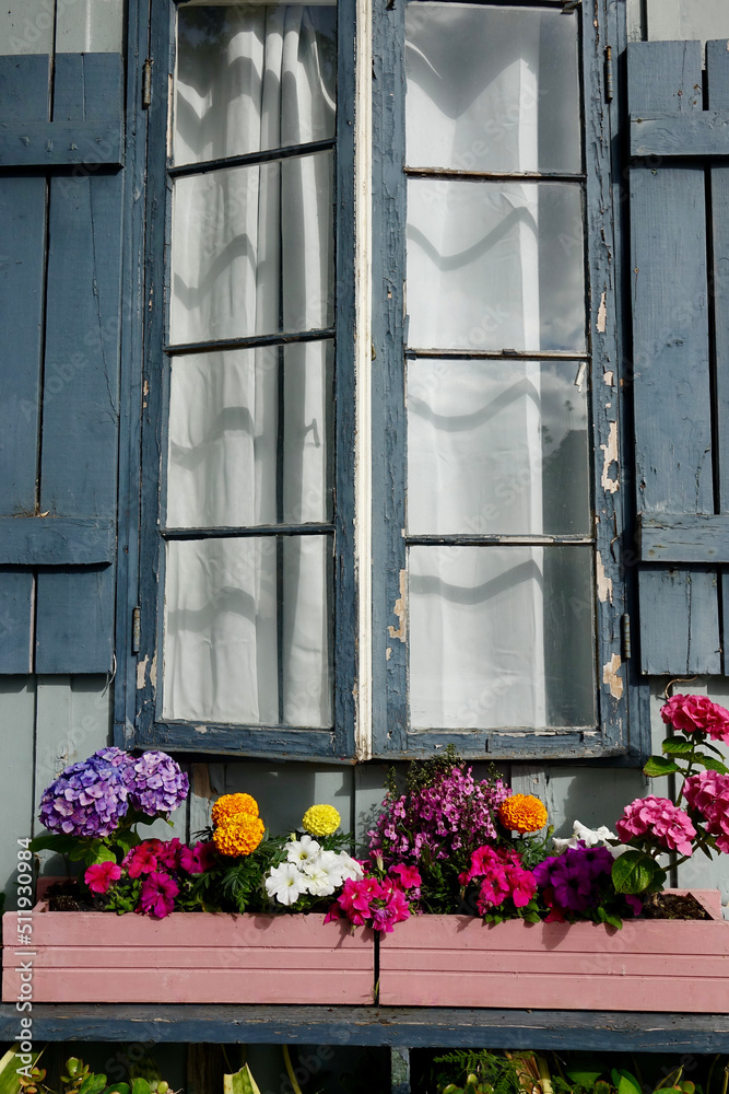 neglected house exterior with colorful flowers