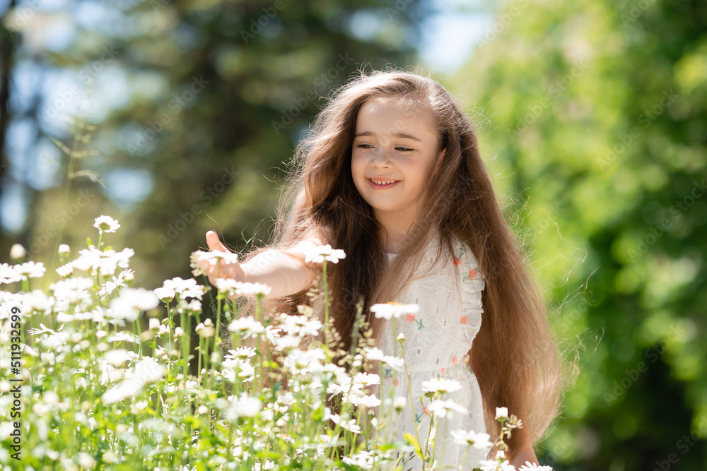 Beautiful Little girl in white dress with flowers in park summertime Beautiful Little girl in white dress with flowers in park summertime