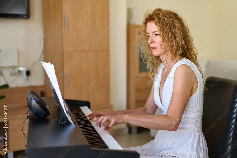 Woman in white dress sitting at the piano. Woman playing piano were digitally modified. Practice at home. Woman in white dress sitting at the piano. Woman playing piano were digitally modified. Practice at home.