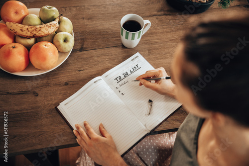 Obraz na płótnie Woman Making To Do List While Enjoying Morning Coffee At Home