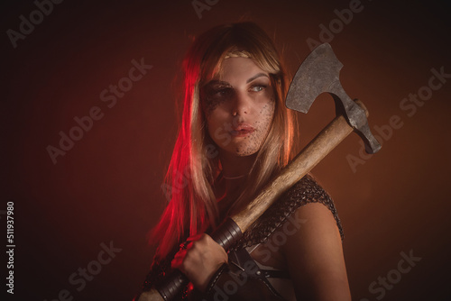 Fotografie Beautiful woman warrior with the axe concept.