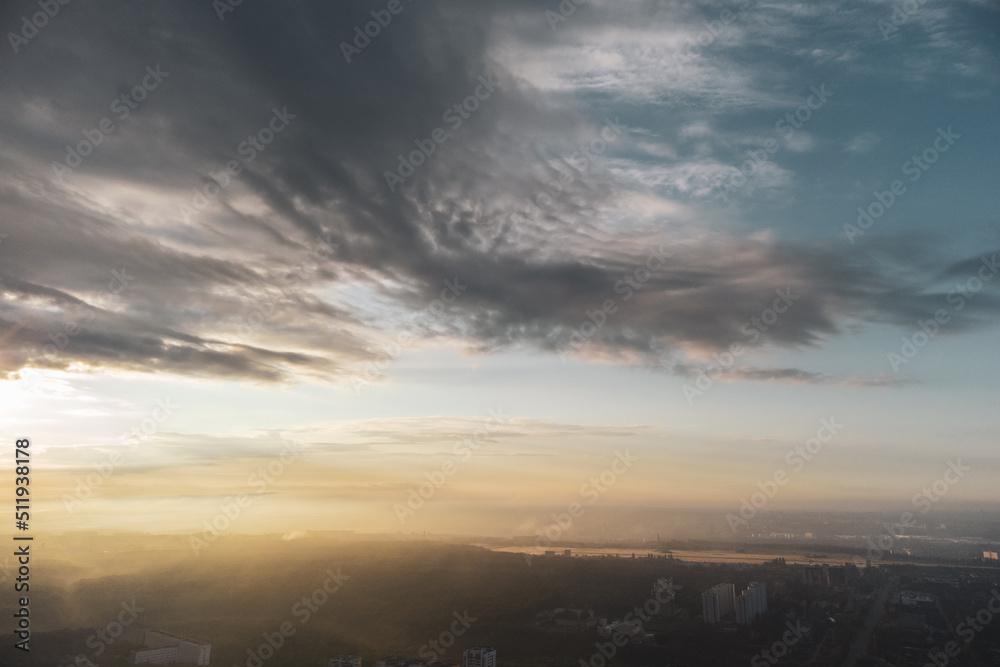 Bright sunrise sun in clouds view above green city residential district. Aerial morning fog in Kharkiv Ukraine. Morning skyscape, cloudscape and streets