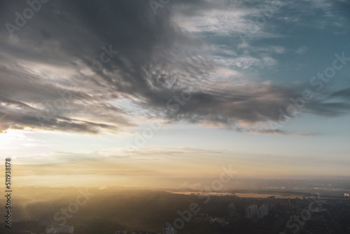 Bright sunrise sun in clouds view above green city residential district. Aerial morning fog in Kharkiv Ukraine. Morning skyscape  cloudscape and streets