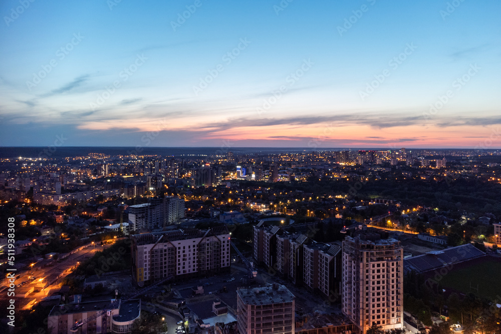 Fototapeta premium Aerial view on vivid evening cityscape, city residential buildings development in sunset. Kharkiv city center in sunset colors, Ukraine