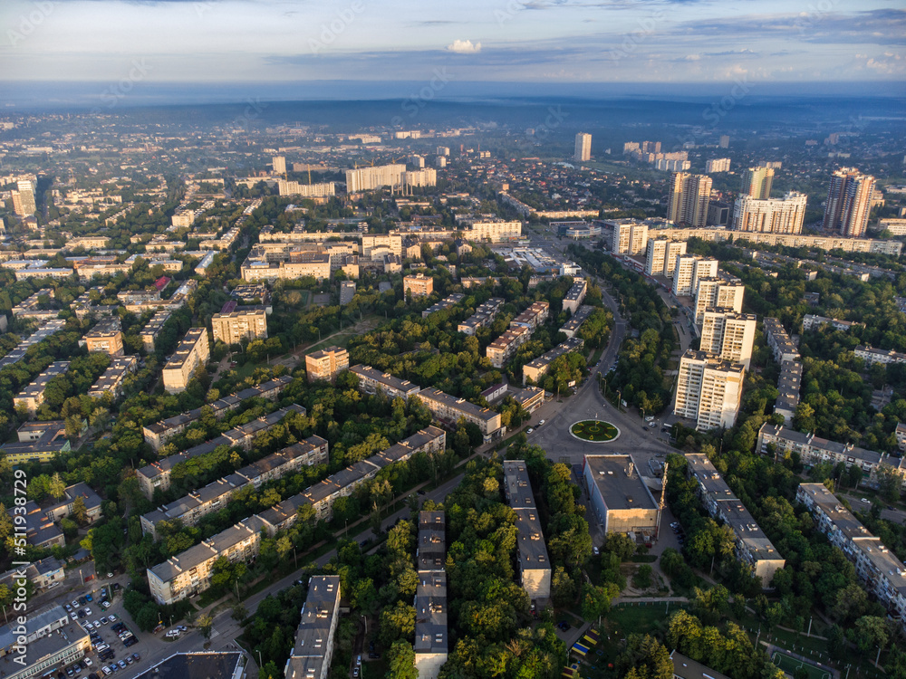 Sunny morning city view in summer green city, residential district. Aerial cityscape above buildings and streets, Pavlovo Pole, Kharkiv Ukraine