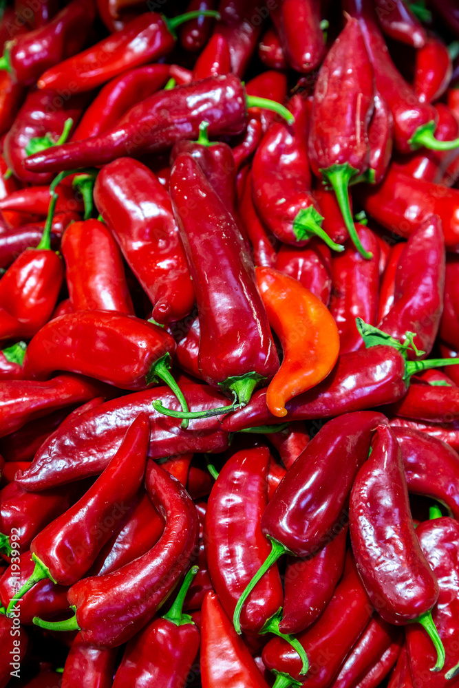 A full frame photograph of vibrant chilli peppers for sale on a market stall