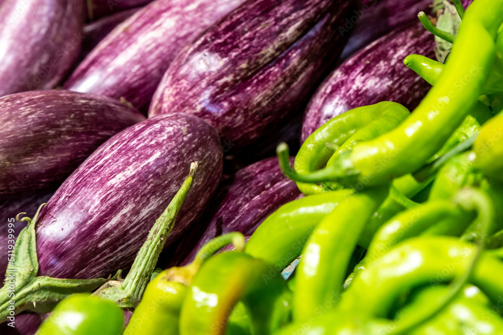 Aubergines/eggplant and chillies for sale on a market stall Aubergines/eggplant and chillies for sale on a market stall