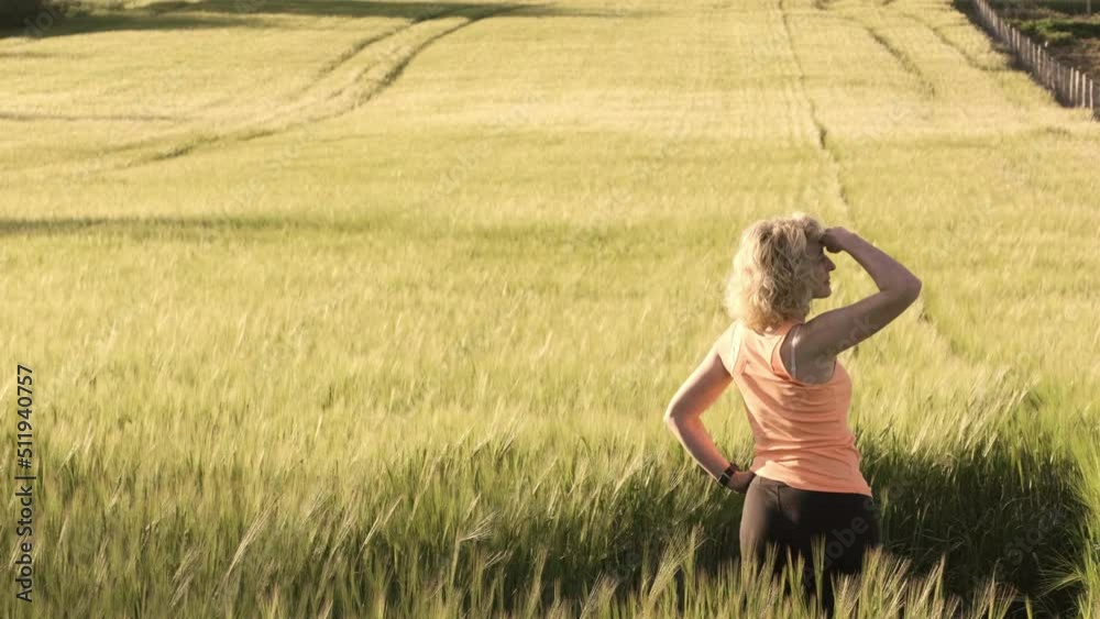 young caucasian mature woman inside a barley field in spring looking around. 4K. Ayegui, Navarre, Spain, Europe. young caucasian mature woman inside a barley field in spring looking around. 4K. Ayegui, Navarre, Spain, Europe.